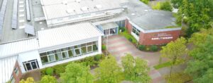 Haupteingang der Schule mit Schriftzug „Europaschule Schulzentrum Saterland“, Vorplatz und Bäumen